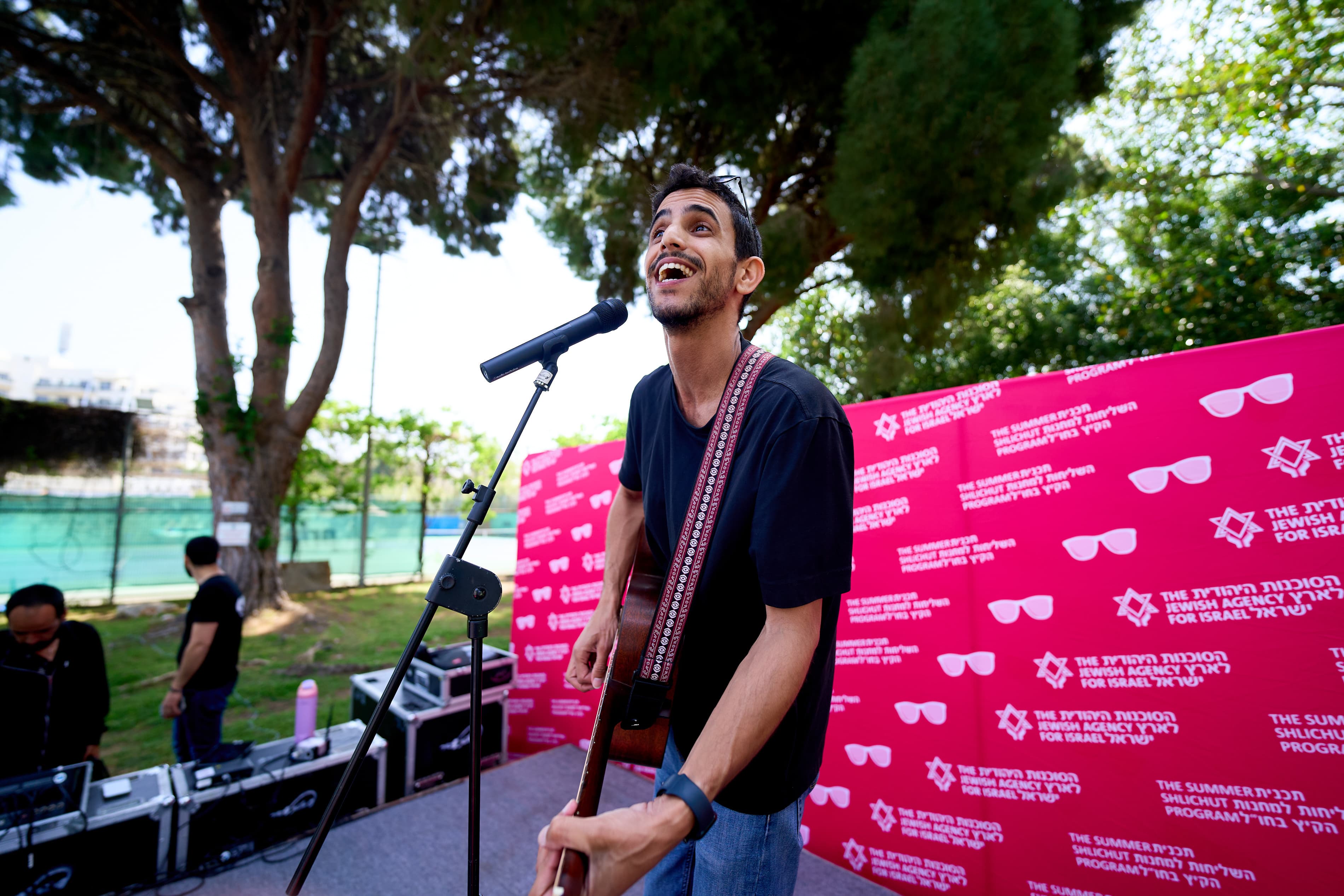 Barak singing and playing guitar at a JAFI event
