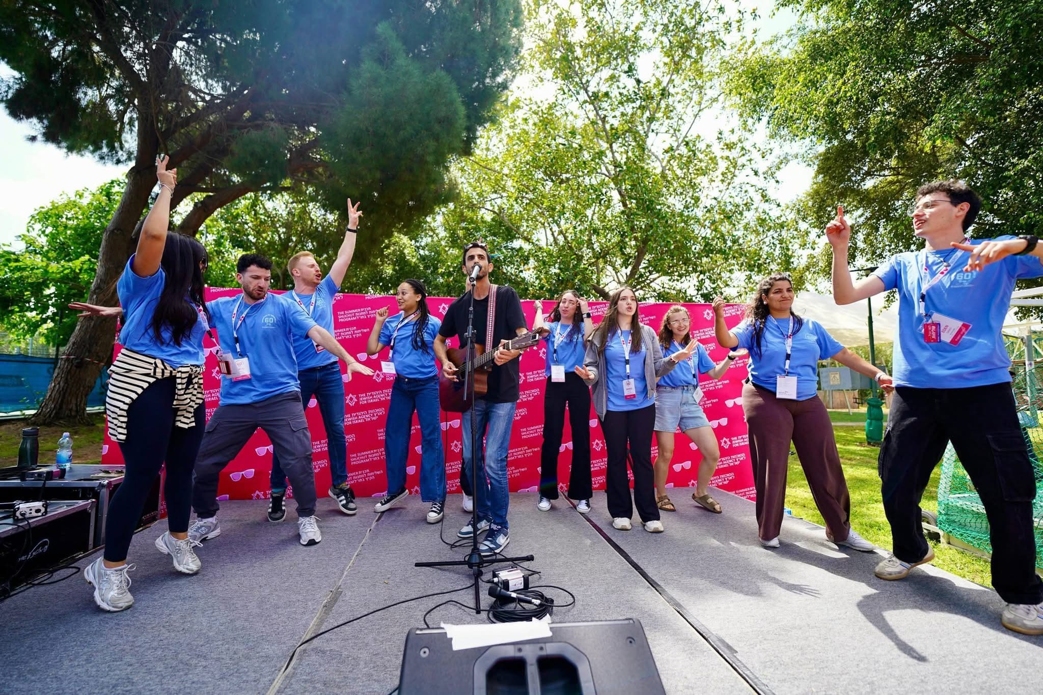 Barak leading a group on an outdoor JAFI stage